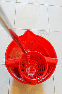 用红色水桶拖把瓷砖地板上有泡沫水图片