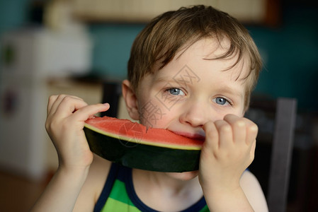 学龄前快乐的小男孩在家吃西瓜图片