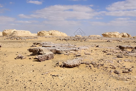 白色泥灰岩和锰岩层上的金色沙子图片
