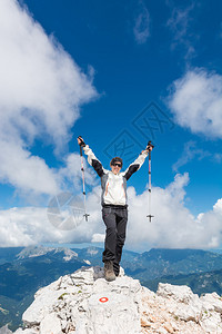 女登山者站在山顶庆祝她成功的升华图片