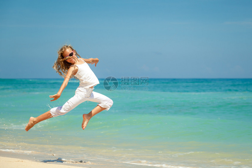 青少年女孩在白天的暑假在蓝海滨滩上图片