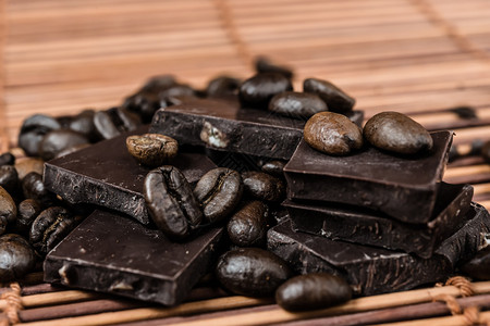 把巧克力和咖啡豆放在棕竹背景图片