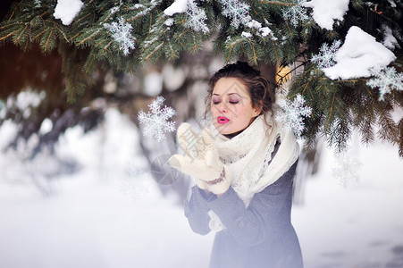 冬天女孩吹在雪花上图片