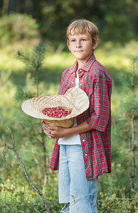 长着满是红野莓的树草帽的站图片