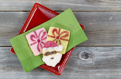 绿色餐巾纸上的圣诞糖饼干和红盘的顶端景色图片