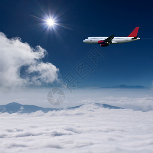 白色飞机高空飞越云层上空与太图片