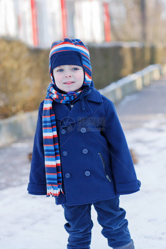 有趣的可爱男孩在美丽的冬天下雪天微笑图片