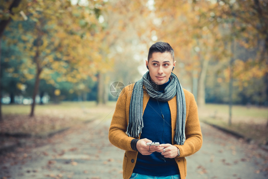 秋季公园户外年轻英俊的白种人使用带耳图片