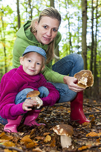 母亲和女儿一起采蘑菇背景图片
