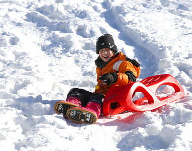 冬天孩子在雪地里玩雪橇图片