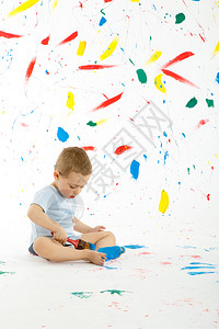 可爱的3岁男孩创造地在墙上地板上涂五颜六色的油漆墙壁地板和到处都是乱背景图片