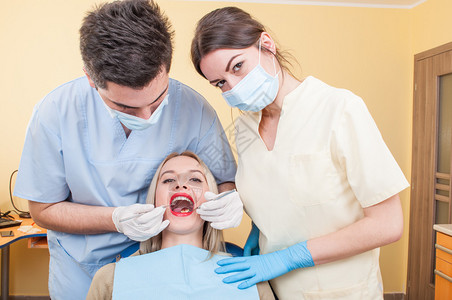 牙医队和美丽的女病人保健概念图片