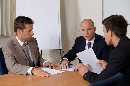 三个商人在会议室背景图片
