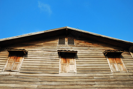 以蓝天为背景的老木泰式房子背景图片