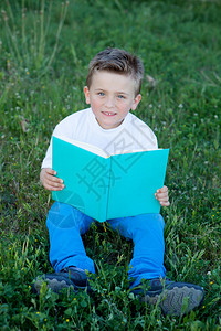 坐在草地上看书的小孩图片