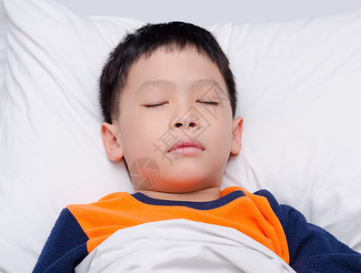 睡觉在床上的小亚裔男孩图片