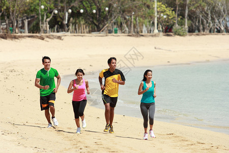 一群四人一起在海滩上奔跑的肖图片