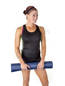 微笑的健身妇女拿着她的运动垫享受在健图片