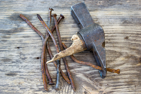 木制背景的指甲和钉子拉图片