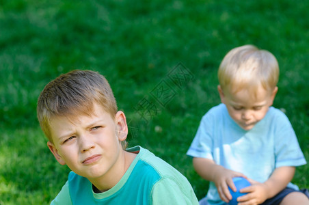悲伤的男孩兄弟在花园图片