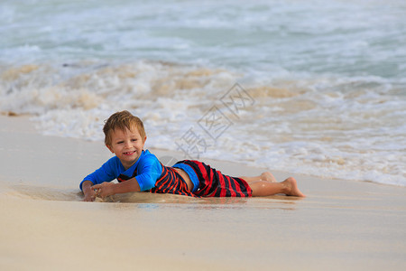 夏日沙滩上玩海浪的小男孩图片