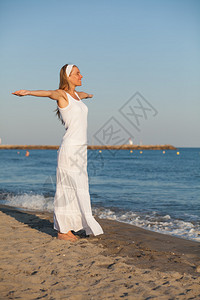 快乐的年轻女士站在沙滩图片