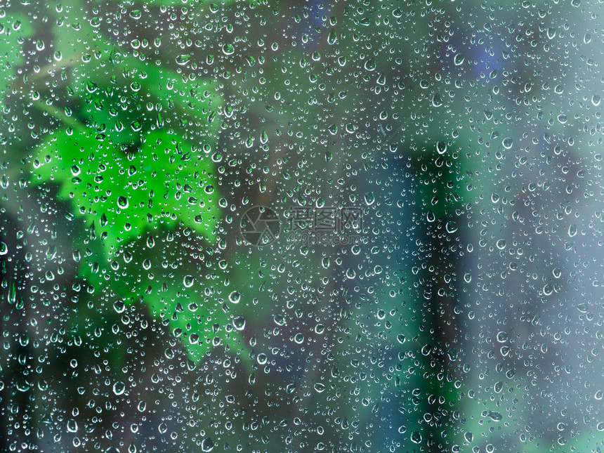 在夜晚下雨时窗户玻璃上的雨滴图片