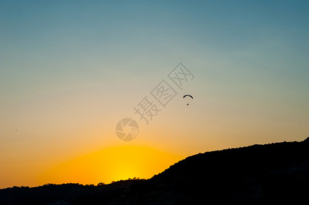 在日落时滑翔伞图片