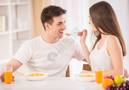 甜美的情侣一起吃早饭女人用玉米图片