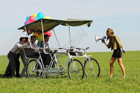 在阳光明媚的绿田日上骑着四轮自行车图片