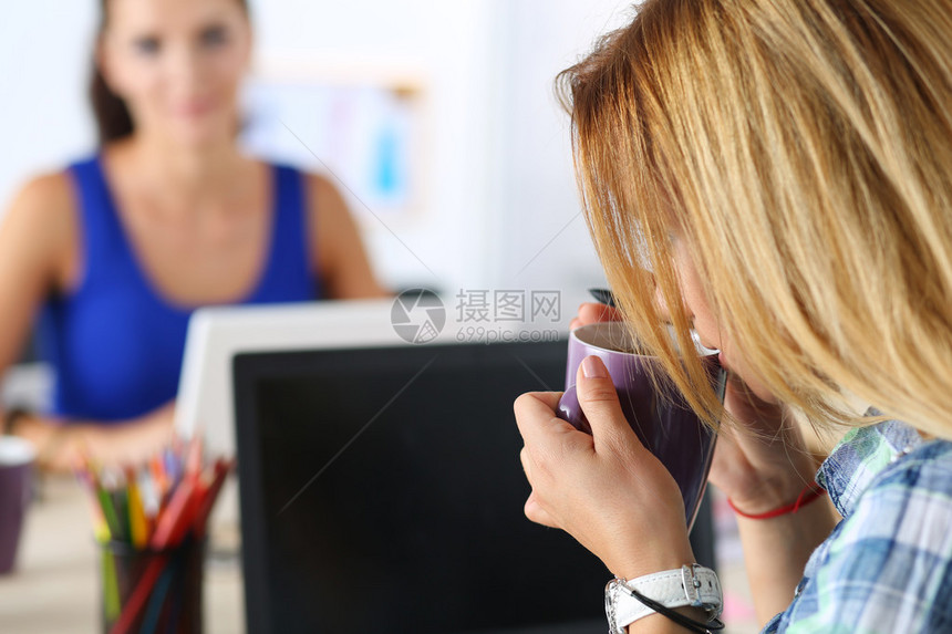 办公室里的两位女设计师喝早茶或咖啡在辛勤工作的一天喝咖啡女员工拿着一杯热饮有创意的人或图片