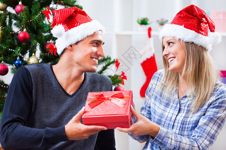 庆祝圣诞快乐的情侣男人正在送礼物图片