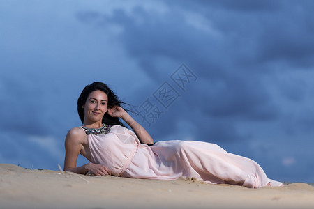 沙丘上穿着白色连衣裙的漂亮女人图片