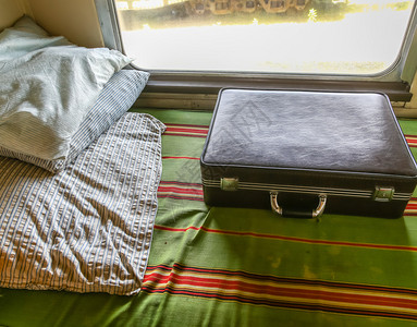 一个手提箱和老羽毛枕头在火车上图片