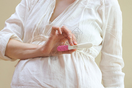 怀孕妇女显示妊娠测试的积极结果对图片