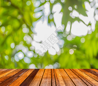 木质地板的模糊图像和绿树颜色背景图片