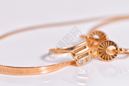 高贵的金耳环和在同一组金蛇链串结的金蛇背景图片