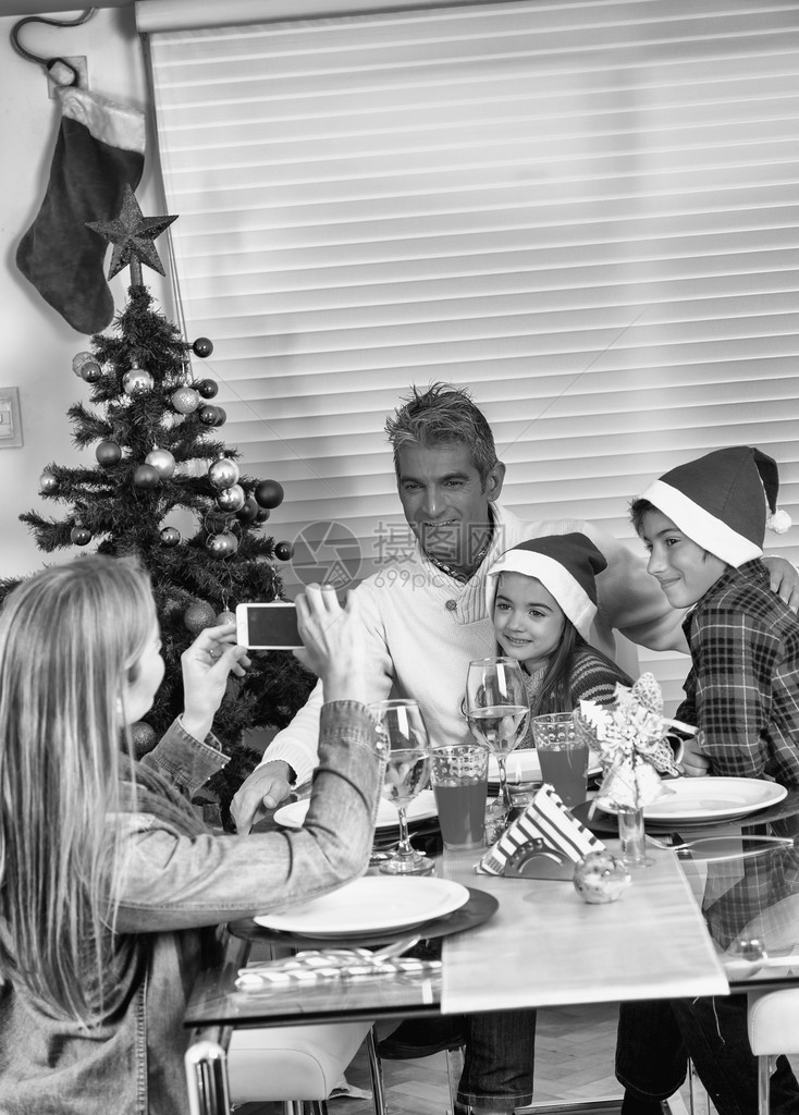 一家人在餐桌上吃圣诞晚餐并拍照图片