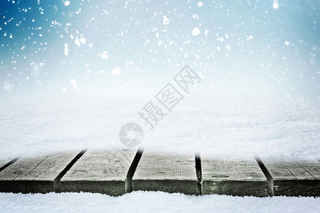 雪堆中的木桌和冬季天空飘落的雪花图片
