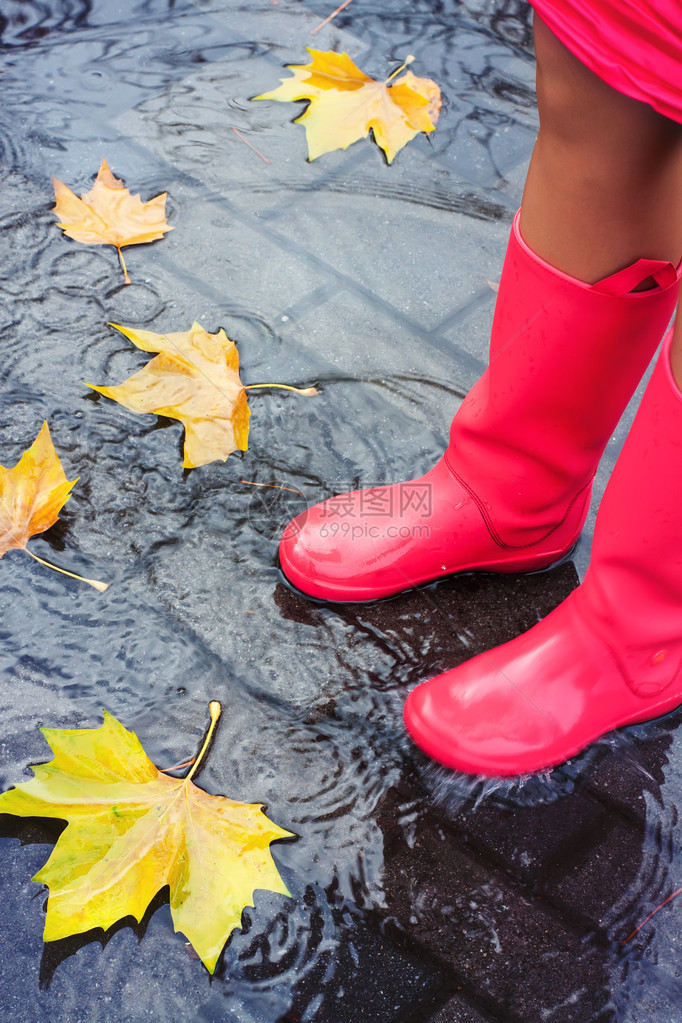 有粉红色橡皮靴的妇女降雨后图片