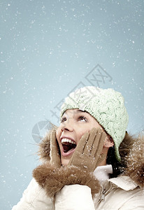 兴奋的女人抬头看着雪图片