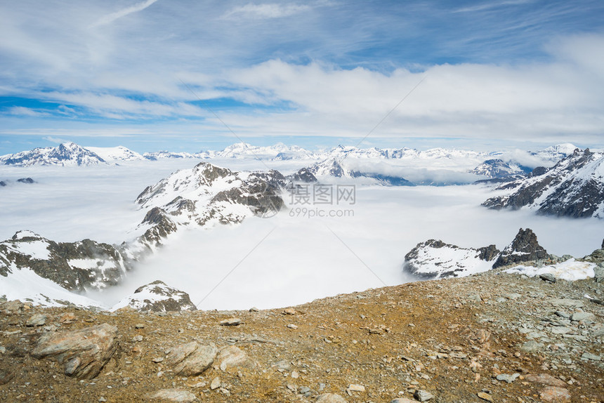 意大利法兰西高山弧高海拔高度的高山峰和雪岩脊的全景云层覆盖了下面的峡谷图片