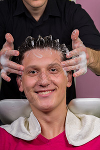 英俊的男客户在沙龙洗头发的肖像图片