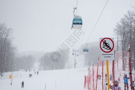 下雪了背景是被雪覆盖的森林和人们滑雪重点是标背景图片