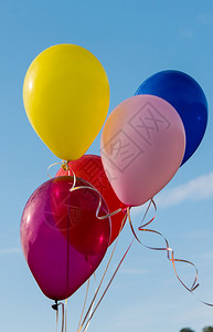 在蓝天上放飞五颜六色的气球图片