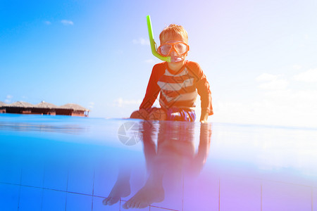 在热带海滩度假胜地游泳的小男孩图片