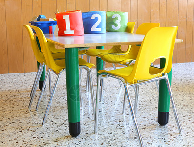带编号的罐子和黄色小椅子的日托课桌教室图片