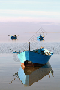 停泊在海湾平静海面上的渔船背景图片