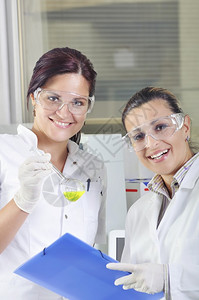 有吸引力的年轻博士生科学家在化学实验室观察溶液蒸馏后绿色指示图片