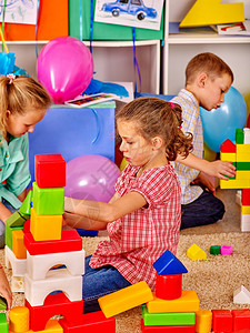 集体儿童一起在幼儿园用地板的砖头玩耍图片